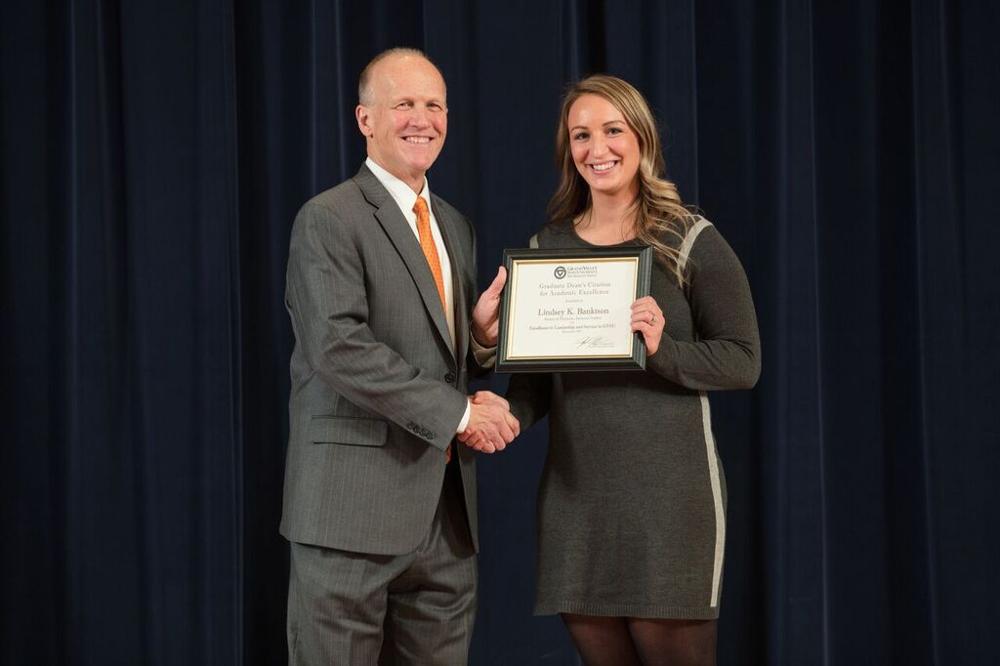 Doctor Potteiger posing for a photo with an award recipient in a grey dress